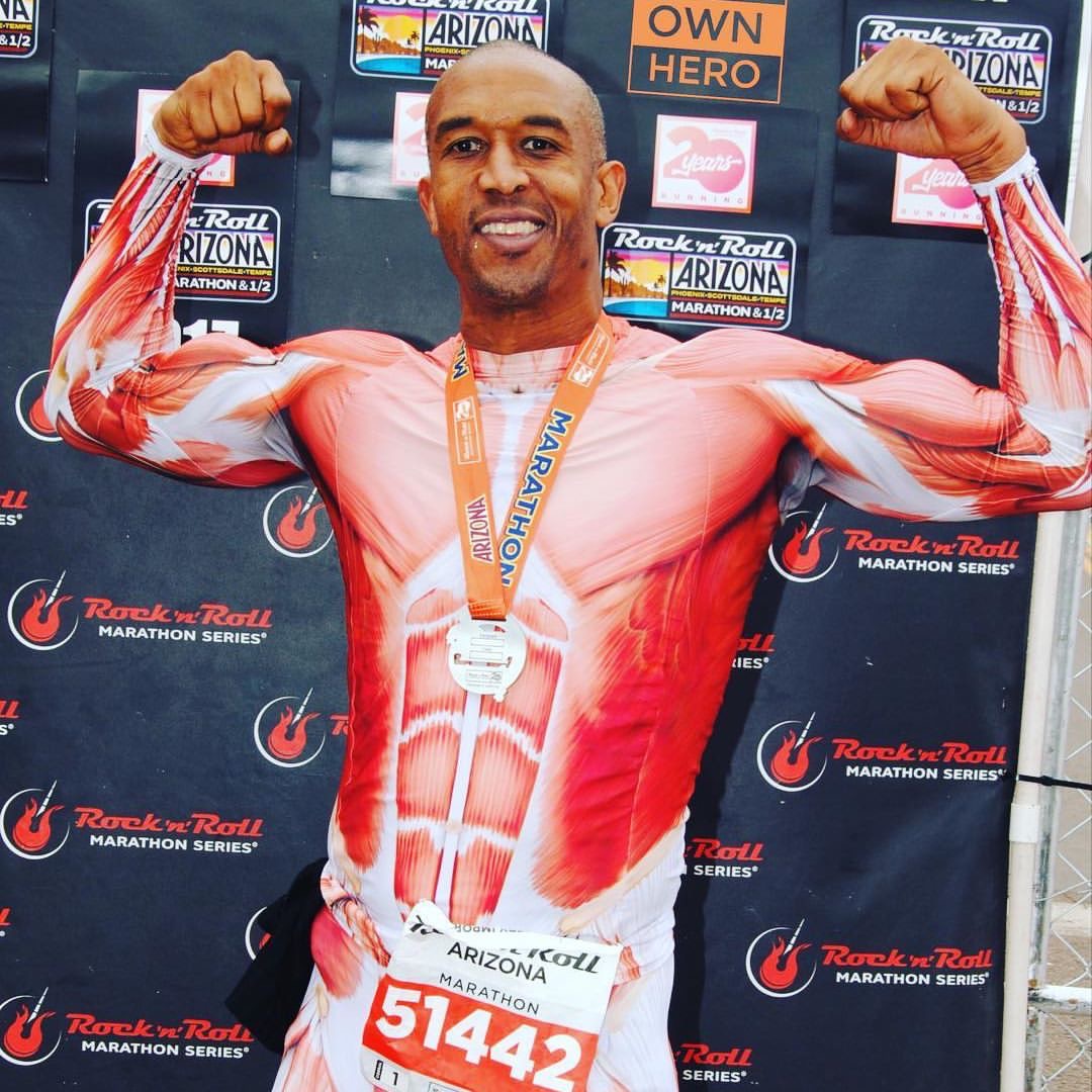 Larry Arnold wearing a finisher medal and a muscle anatomy race suit