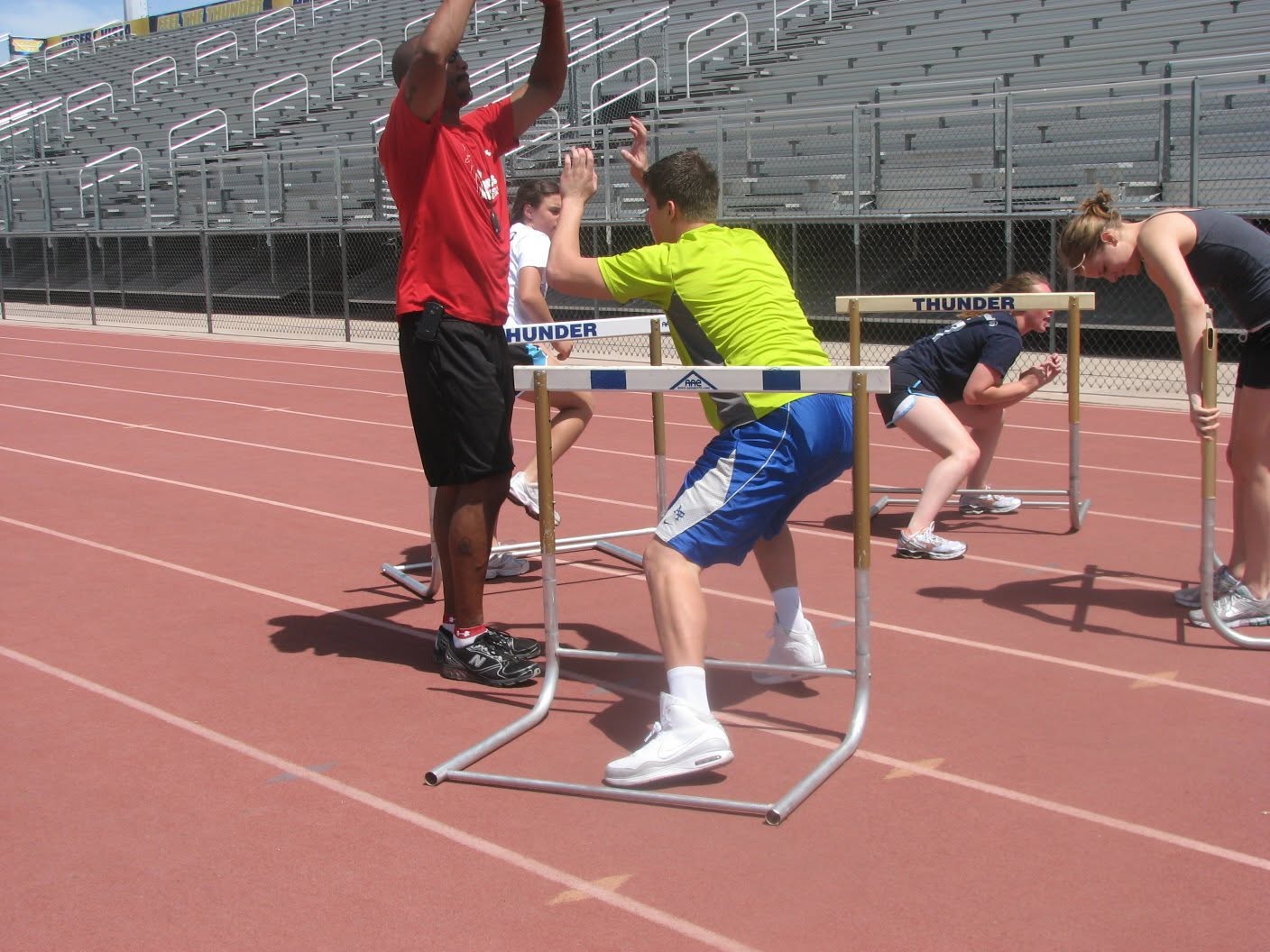 Hands-on instruction during a hurdle movement drill.