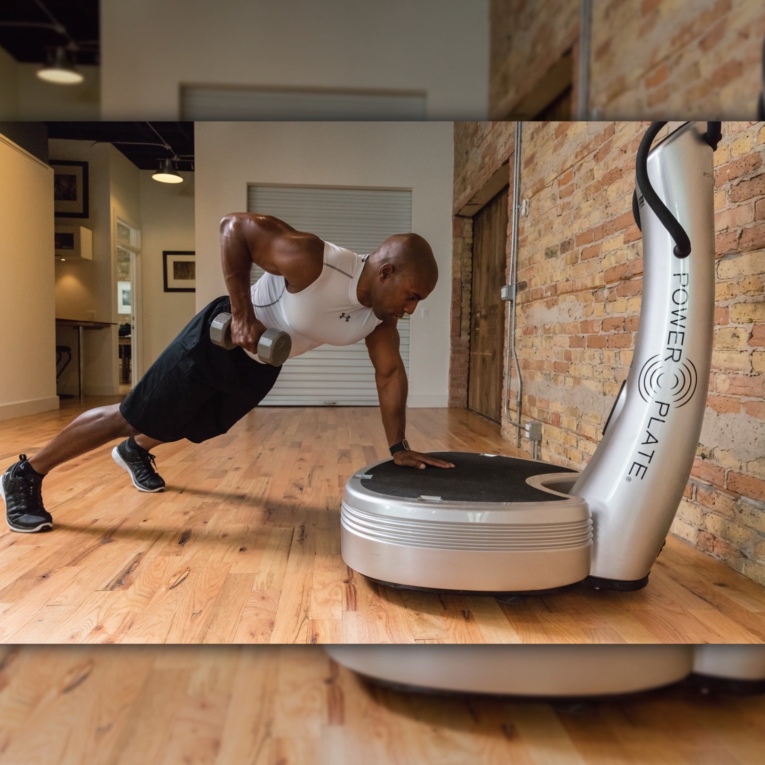 Athlete performing a dumbbell row with a Power Plate